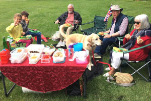 People and a Labrador sat round a table with food