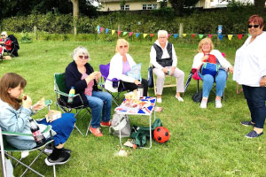People sitting in chairs outside smiling