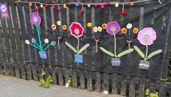 knitted flowers on a fence