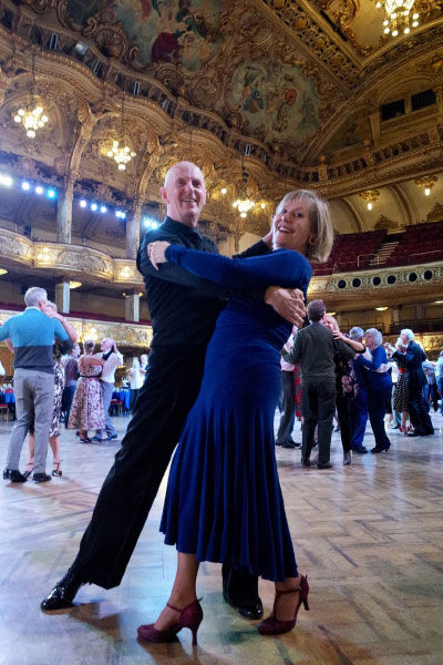 A couple dancing in a grand ballroom 