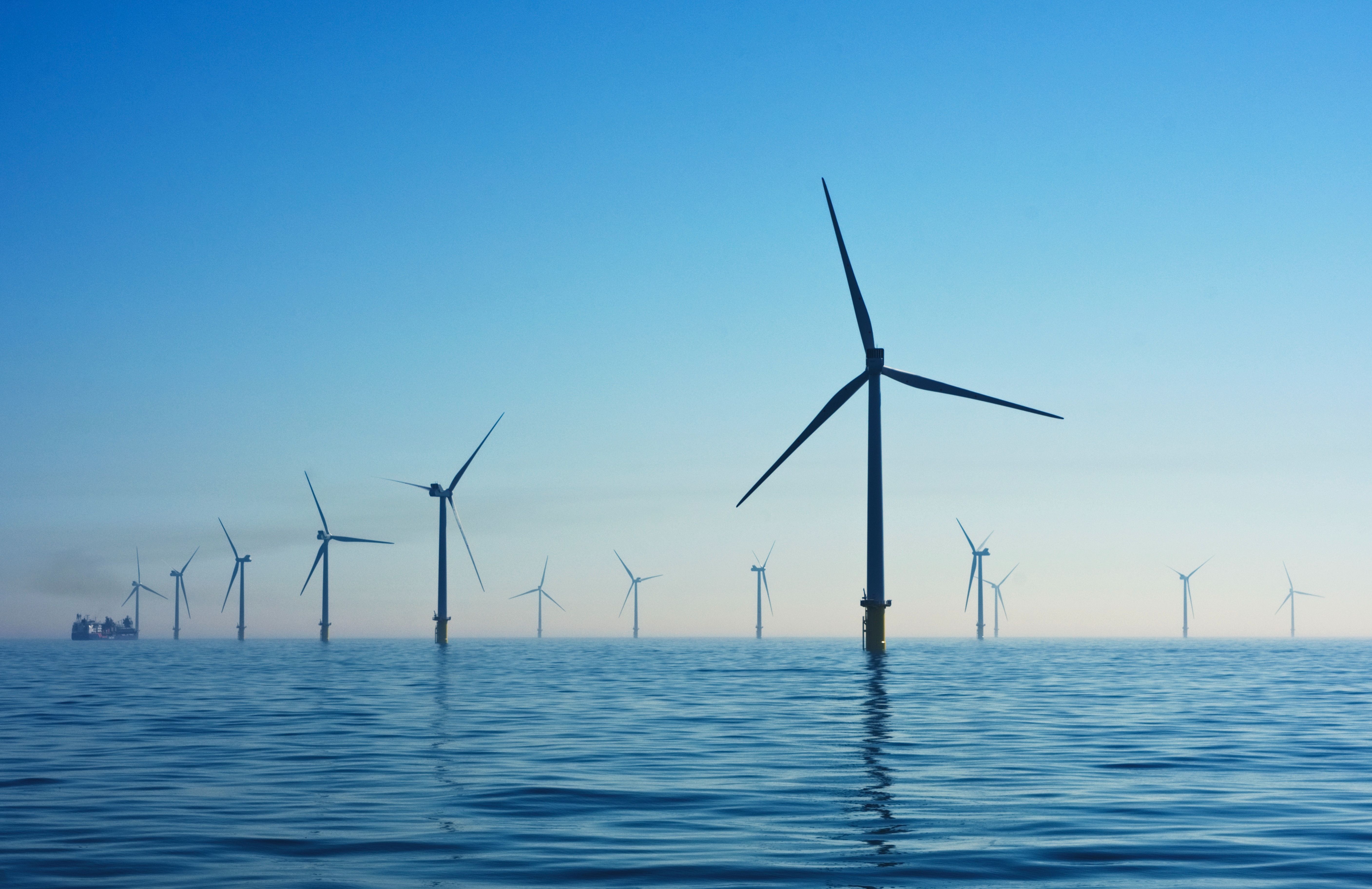 an offshore wind farm. the sea is calm and the sky is blue.