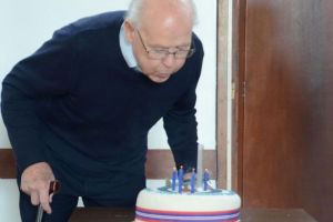 A man is blowing out candles on a birthday cake