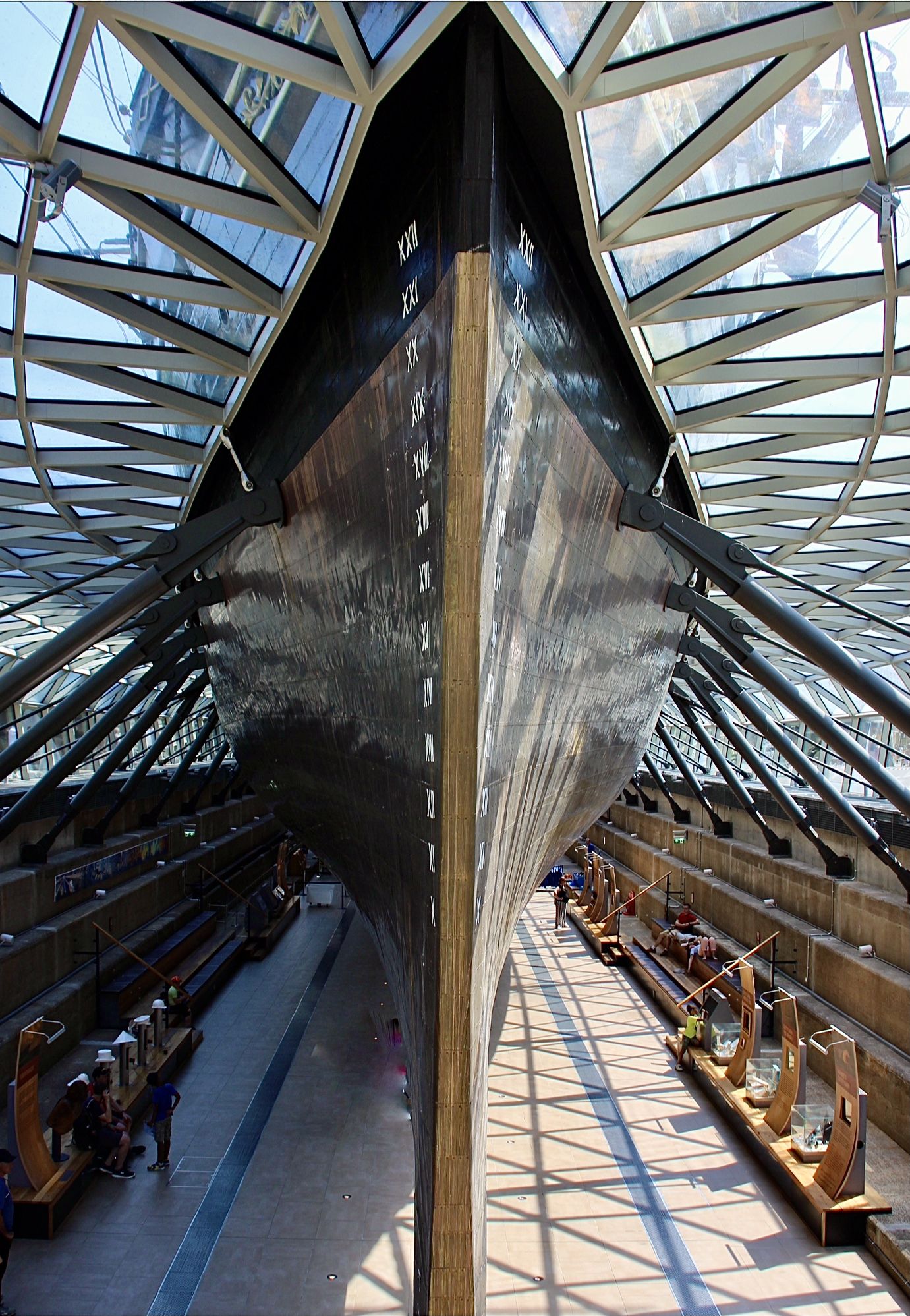 the bottom of the front of a huge wooden boat, on display out of the water. 
