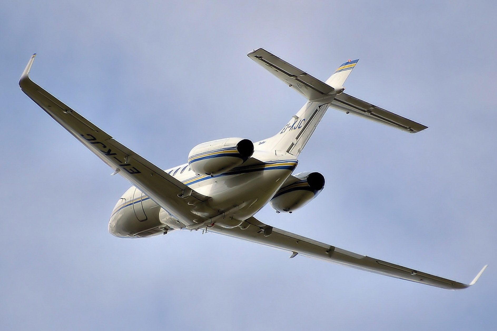 small white plane flying in blue sky