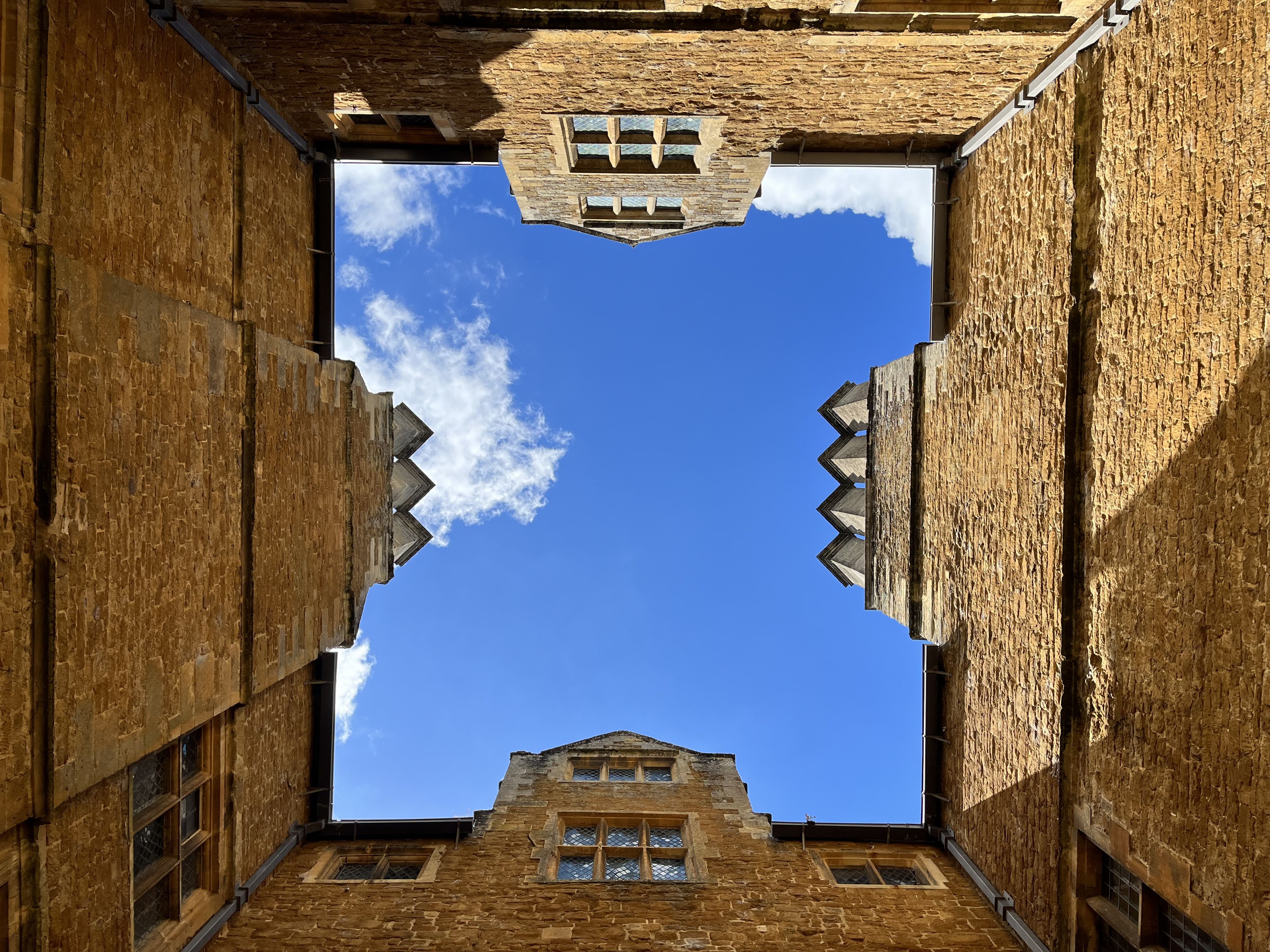 In a square of buildings looking up at the blue sky 