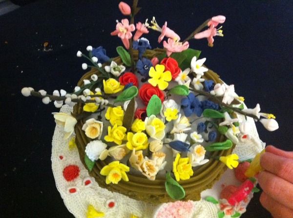 a floral decorated cake with branches and lots of colourful different types of flowers