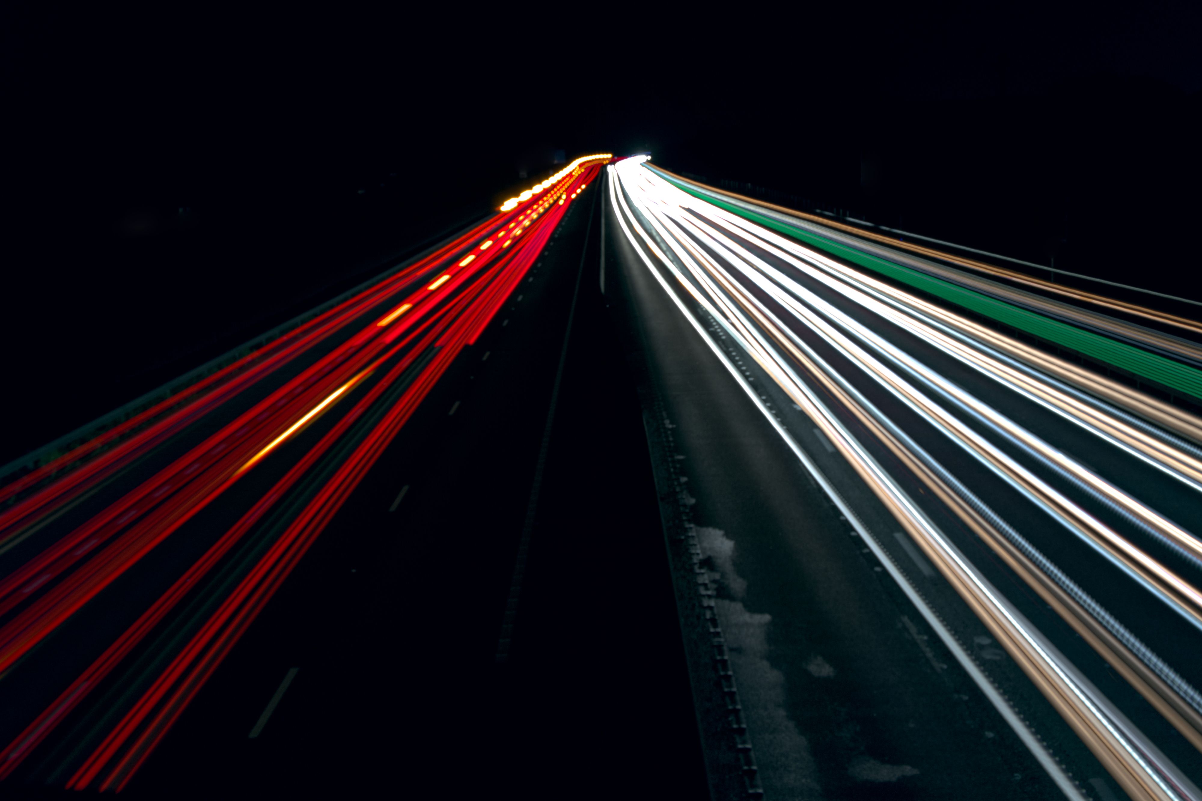 two lines of light in the dark, the left lines are red and the right are white